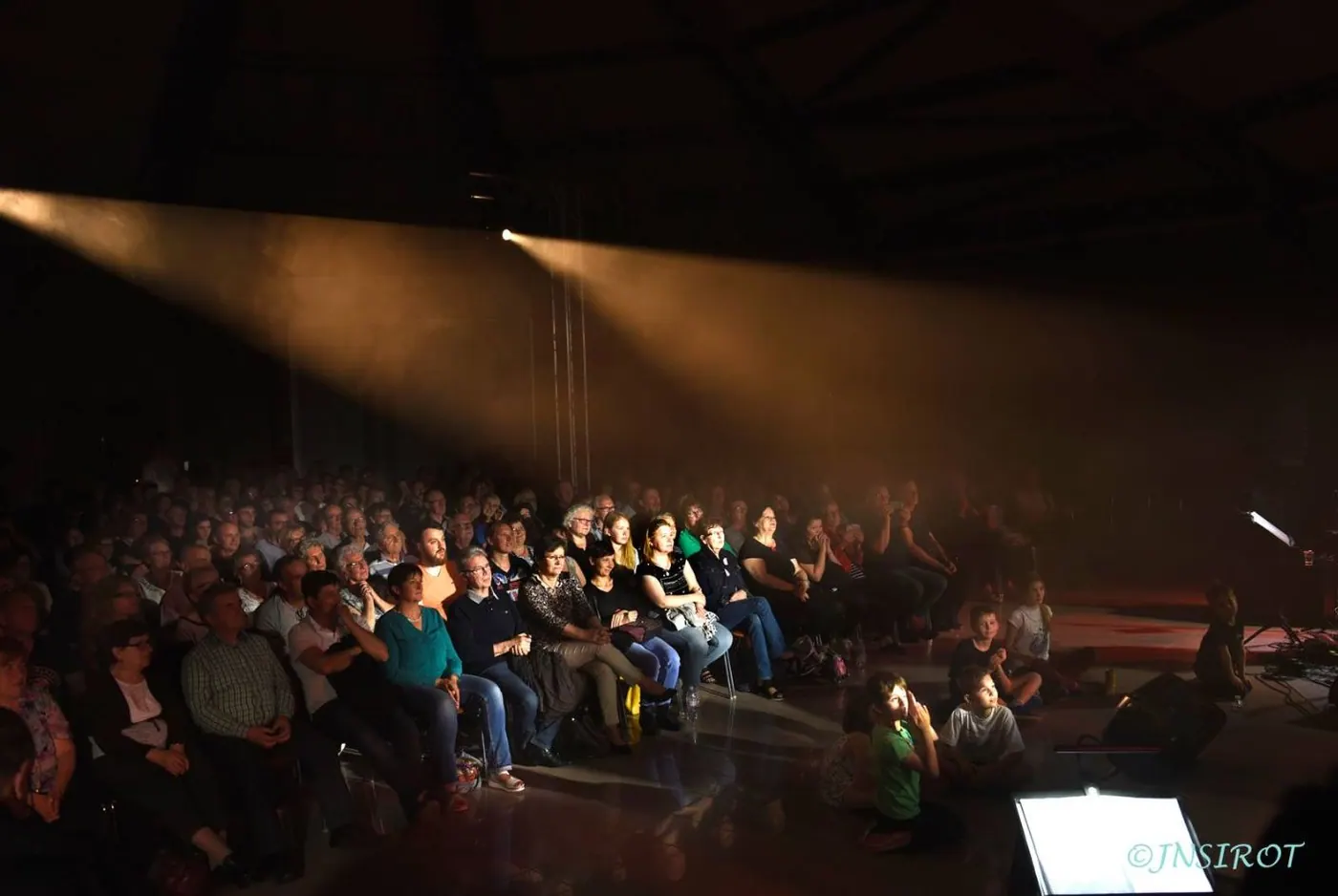 Vue large d'un concert, claviers au premier plan et chœur sur gradins
