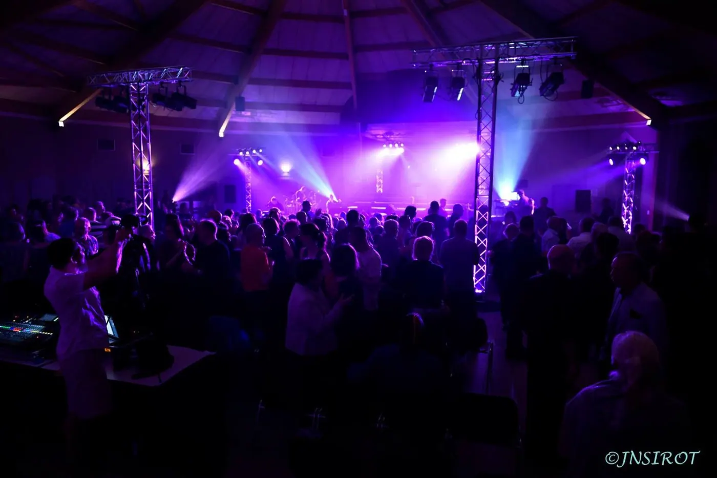 Salle comble sous les lumières violettes pendant un concert